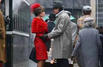 Penelope Cruz in red dress and Daniel Day Lewis in coat stand close in scene