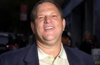 Unidentified man smiling outdoors in a suit jacket