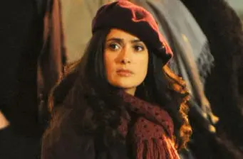 Salma Hayek in maroon beret and scarf in a movie still