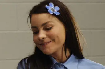 Sofia Vergara smiling looking down wearing blue with flower hair clip
