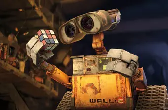 Wall-E robot holding a Rubik's Cube in a dark room