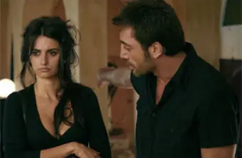 woman looks unhappy as man speaks to her inside a room