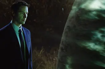 Man in suit looking at large glowing sphere in dark scene