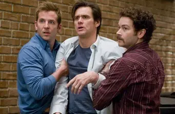 Three men look surprised, holding each other in Yes Man movie scene