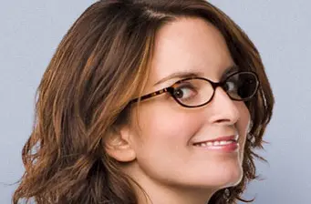 Headshot of Tina Fey smiling with glasses and light brown hair