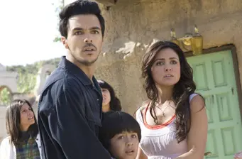 Two adults and two kids look surprised outside near green door