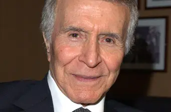Headshot of Ricardo Montalban smiling indoors