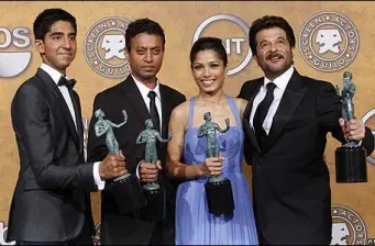 Four winners hold SAG Awards statues smiling in suits and gown