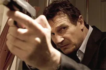 Man in suit aims gun with focused expression