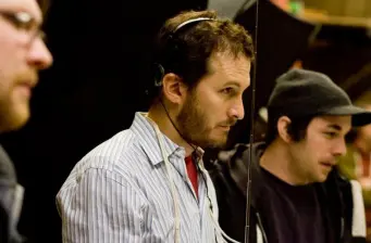 man with headset in striped shirt concentrating at event