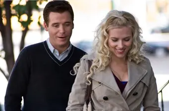 Man in sweater and woman in beige jacket walking and talking