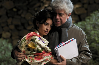 man and woman embrace, woman wearing floral shawl holding papers