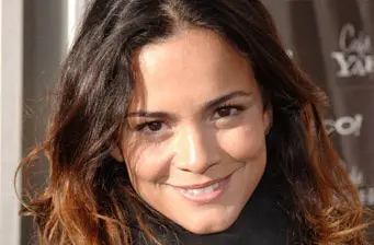 Close-up of smiling woman with dark hair in natural light