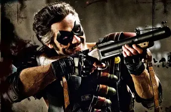 Rorschach aiming a shotgun in dark Watchmen movie scene