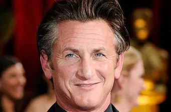 Headshot of Sean Penn smiling with blurred crowd behind him