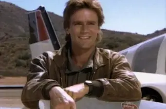 Man in brown leather jacket smiles near small airplane outdoors