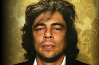 Headshot of Benicio del Toro with textured wallpaper background