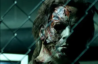 Michael Myers close-up with damaged mask behind chain-link fence