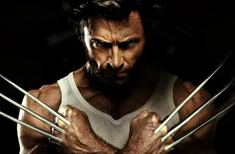 Wolverine crosses arms with claws extended, intense look