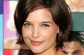 Headshot of Katie Holmes smiling with short brown hair
