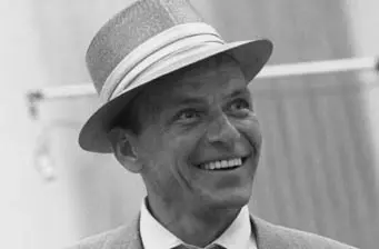 Frank Sinatra smiling in fedora hat black and white photo