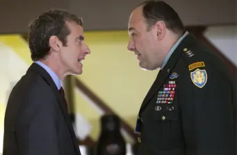 A man in suit confronts uniformed military officer in heated exchange