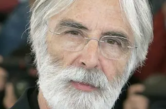 Headshot of Michael Haneke with white beard and glasses