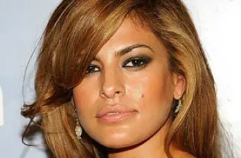 Close-up headshot of Eva Mendes with styled blond hair and earrings