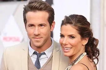 Ryan Reynolds and Sandra Bullock smile together at red carpet event