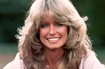 Farrah Fawcett smiling in classic feathered hairstyle headshot