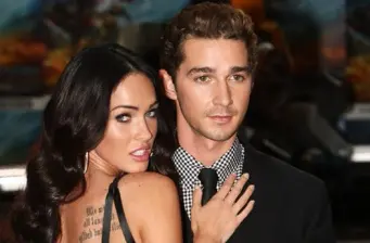 Close-up of woman with dark hair touching man's suit chest