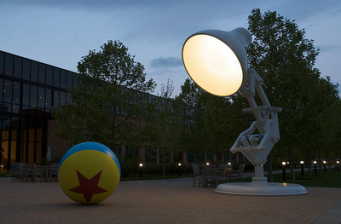 Pixar's Luxo Jr. lamp and ball statue outside studio at dusk