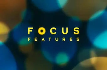 Focus Features logo in yellow on blurred blue background