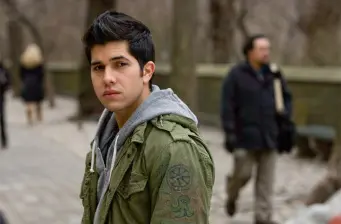 Walter Perez in green jacket looks at camera outdoors