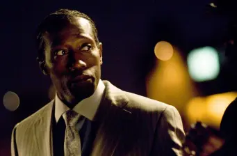 Wesley Snipes wearing suit looking sideways in dark movie scene