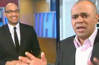 Two men in suits, one smiling and another speaking