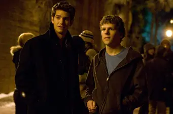 Two young men talking outside at night in coats