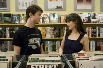 man and woman browse vinyl records in a shop and talk