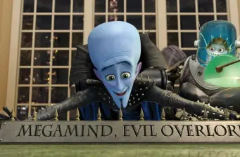 Megamind and Minion examine 'Megalind, Evil Overlord' plaque indoors
