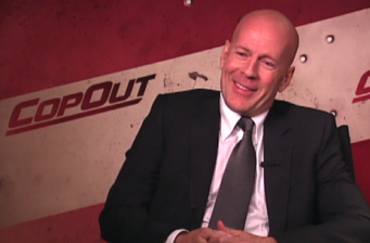 Bruce Willis smiling in suit during interview or press event