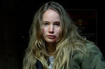 blonde woman in green jacket looks at camera headshot
