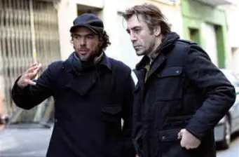 two men dressed in black having a discussion outside