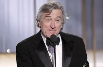 Robert De Niro speaks at 2011 Golden Globes podium in tuxedo