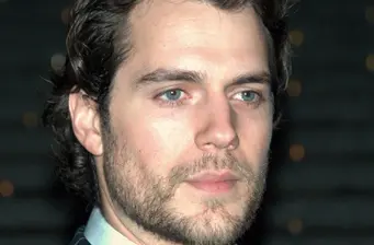 Headshot of Henry Cavill looking off camera with slight beard
