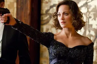Marion Cotillard aiming a gun in a tense scene