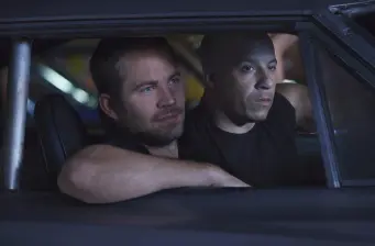 Two men sitting inside a car, arms resting on window frame