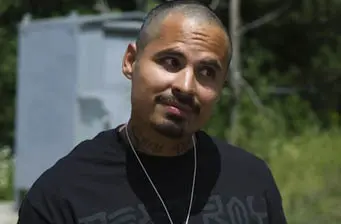 Michael Peña close-up outdoors wearing black shirt, slight smile