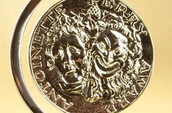 Tony Awards medallion featuring comedy and tragedy masks close-up