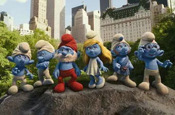 Six Smurfs characters posing on a rock in a city park