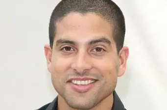 Headshot of actor Adam Rodriguez smiling at the camera